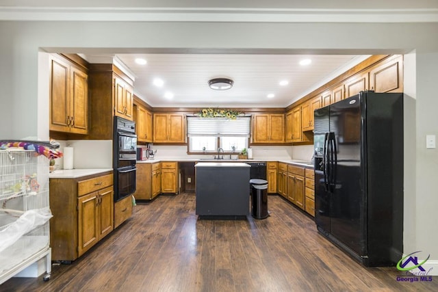 kitchen with black appliances, dark hardwood / wood-style floors, crown molding, and a center island