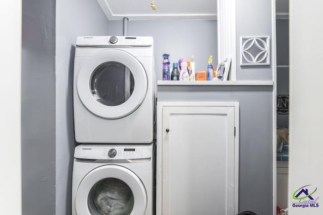 clothes washing area featuring stacked washer and dryer