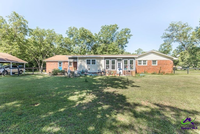 rear view of property featuring a lawn