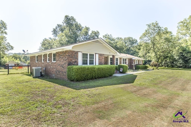 view of front facade featuring a front yard and central AC