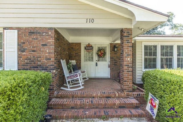 view of exterior entry featuring covered porch