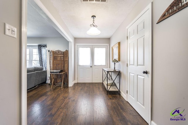 foyer entrance featuring a textured ceiling, a healthy amount of sunlight, and french doors