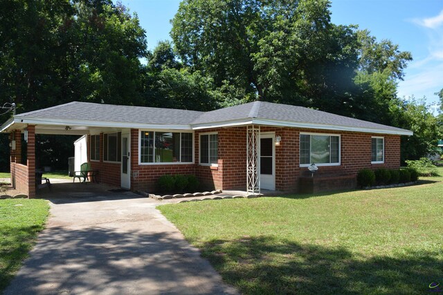 ranch-style home featuring a carport and a front lawn