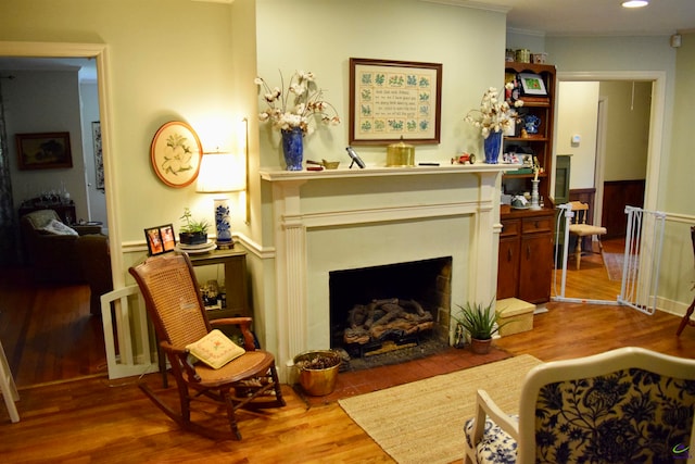 living room with wood-type flooring and ornamental molding