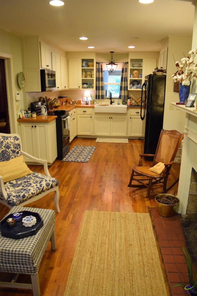 kitchen with white cabinets, stainless steel appliances, hardwood / wood-style floors, and sink