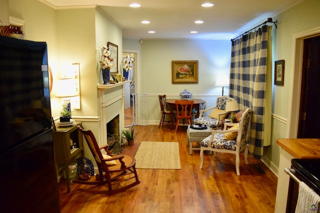 sitting room with hardwood / wood-style flooring and ornamental molding