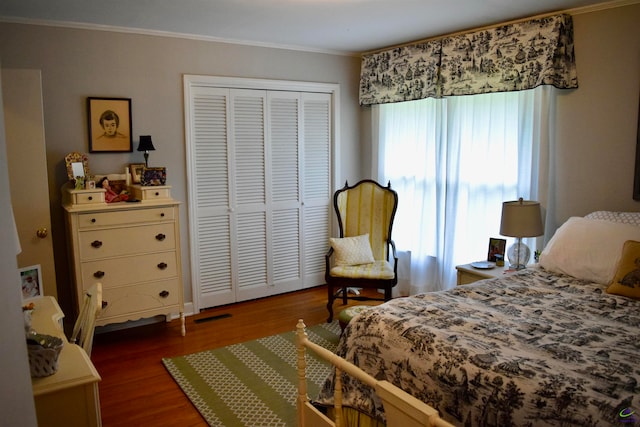 bedroom featuring ornamental molding, a closet, and dark hardwood / wood-style floors