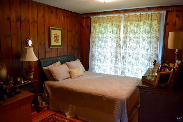 bedroom with wood walls and hardwood / wood-style flooring