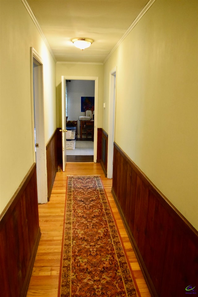 hallway featuring light wood-type flooring and ornamental molding