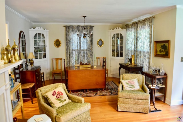 sitting room with an inviting chandelier, wood-type flooring, and ornamental molding