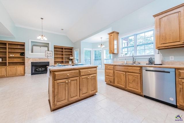 kitchen featuring hanging light fixtures, built in shelves, dishwasher, and a fireplace