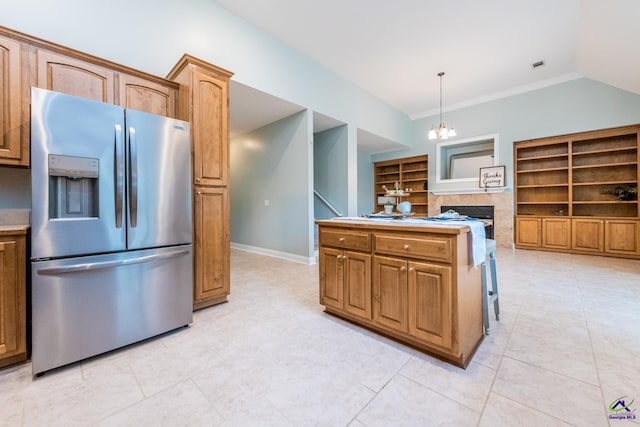 kitchen with a notable chandelier, a tile fireplace, pendant lighting, stainless steel refrigerator with ice dispenser, and built in shelves