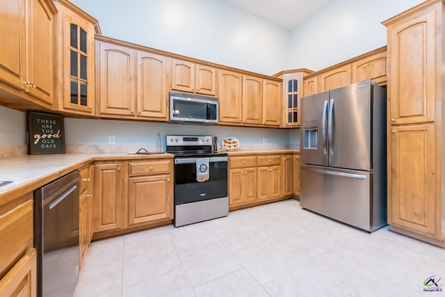 kitchen featuring light tile patterned flooring and appliances with stainless steel finishes