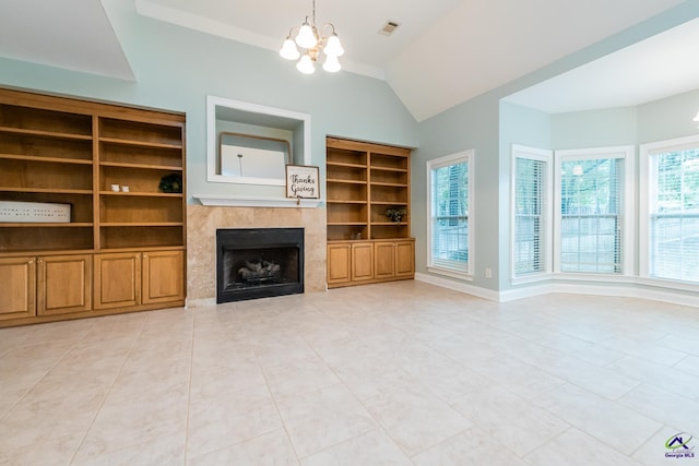 unfurnished living room with a chandelier, built in features, lofted ceiling, and a tiled fireplace