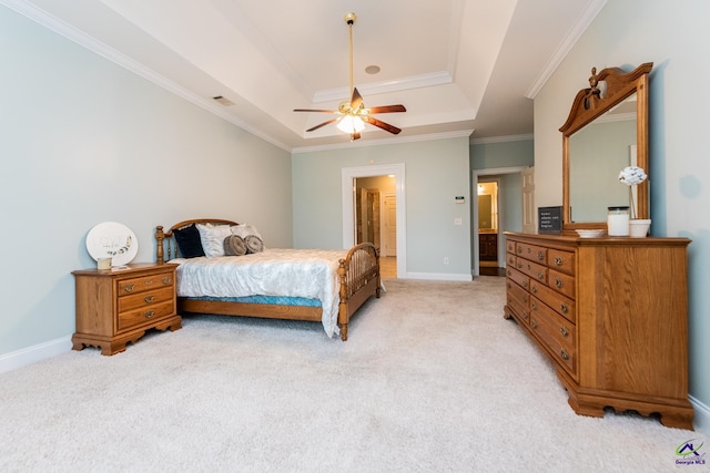 bedroom with ceiling fan, ensuite bathroom, light carpet, and a raised ceiling