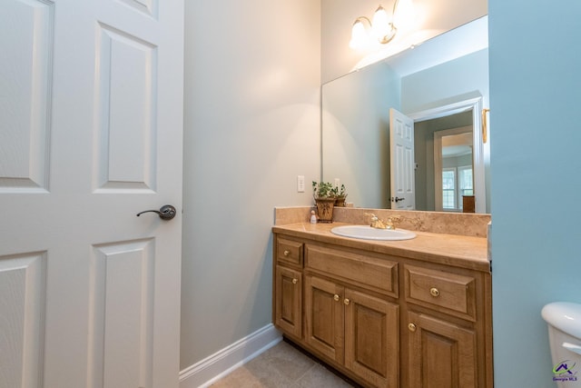 bathroom featuring toilet, vanity, and tile patterned flooring