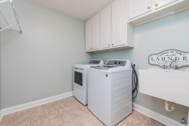 clothes washing area featuring cabinets, light tile patterned floors, washing machine and clothes dryer, and sink