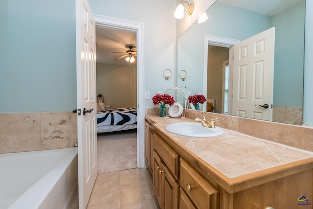 bathroom with ceiling fan, vanity, tile patterned floors, and a washtub