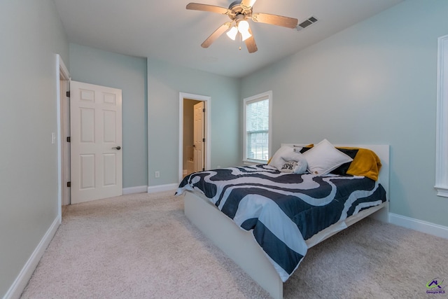 carpeted bedroom with ceiling fan and ensuite bathroom