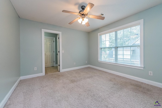 spare room featuring ceiling fan and light colored carpet