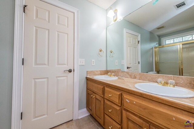 bathroom featuring vanity, tile patterned floors, and an enclosed shower