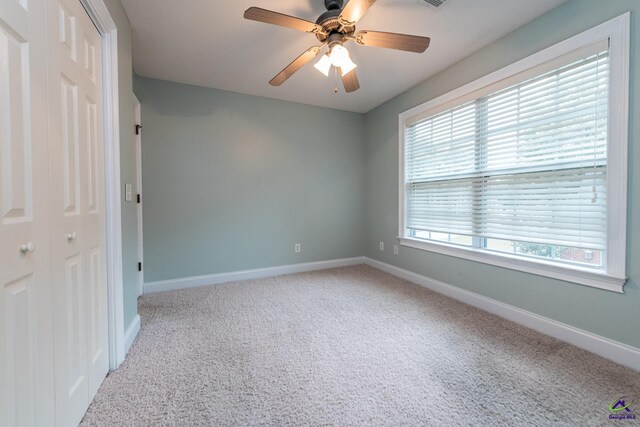 carpeted empty room featuring ceiling fan