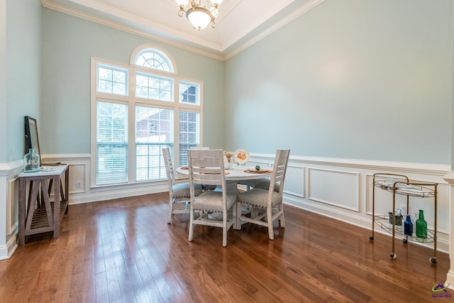 dining area with dark hardwood / wood-style flooring, a healthy amount of sunlight, ornamental molding, and a notable chandelier