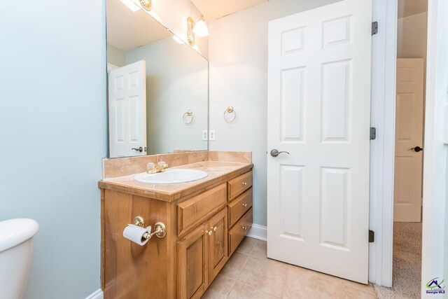 bathroom featuring toilet, tile patterned flooring, and vanity