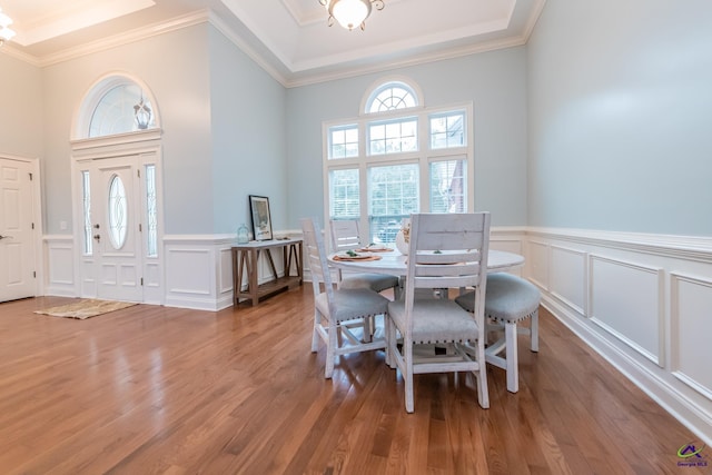 dining room with wood-type flooring, an inviting chandelier, and ornamental molding