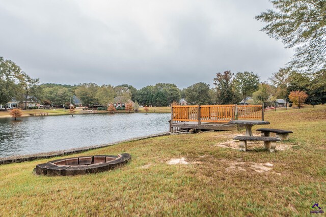 exterior space featuring a water view and an outdoor fire pit