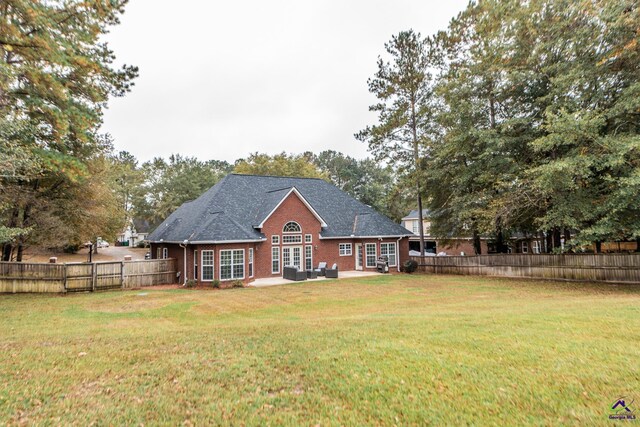 back of property with a patio area and a lawn