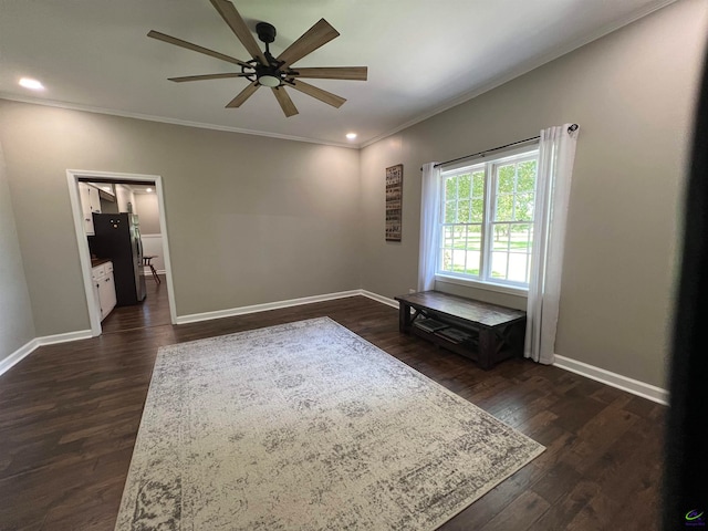 empty room featuring ceiling fan, dark hardwood / wood-style floors, and crown molding