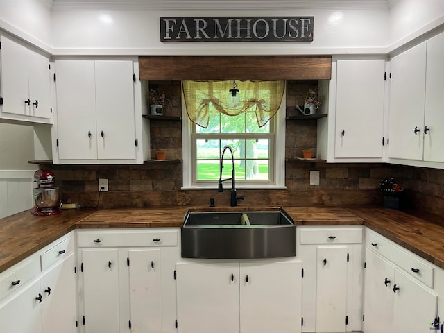 kitchen with wooden counters, sink, and tasteful backsplash