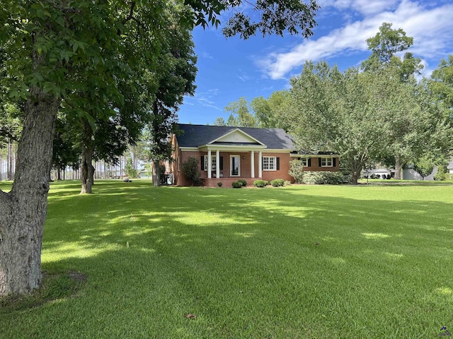 view of front facade featuring a porch, a front yard, crawl space, and brick siding