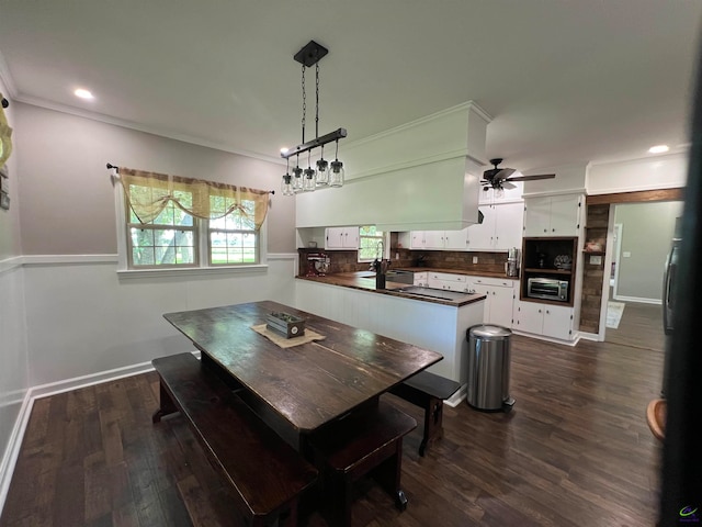 dining area with crown molding, dark hardwood / wood-style flooring, and ceiling fan