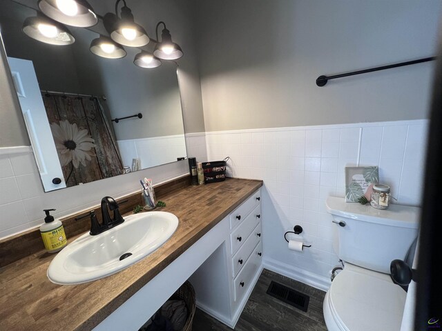 bathroom with vanity, decorative backsplash, tile walls, and toilet