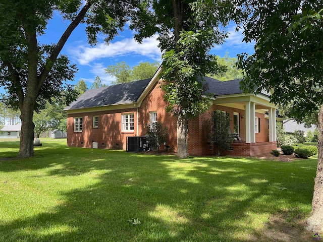 view of front of home with central AC unit and a front yard