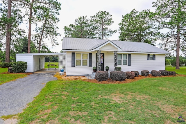 single story home with a carport, a front yard, metal roof, and aphalt driveway