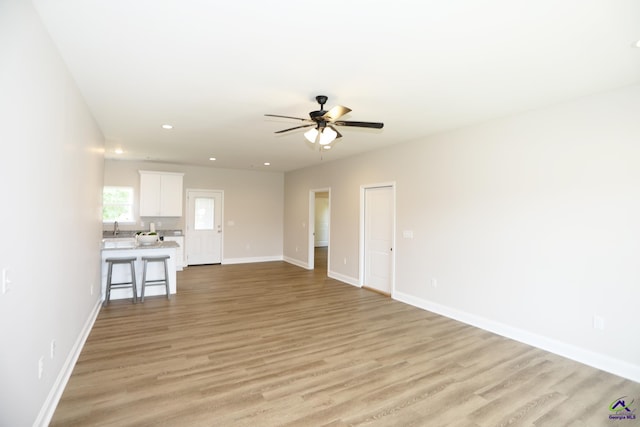 unfurnished living room with ceiling fan and light hardwood / wood-style floors