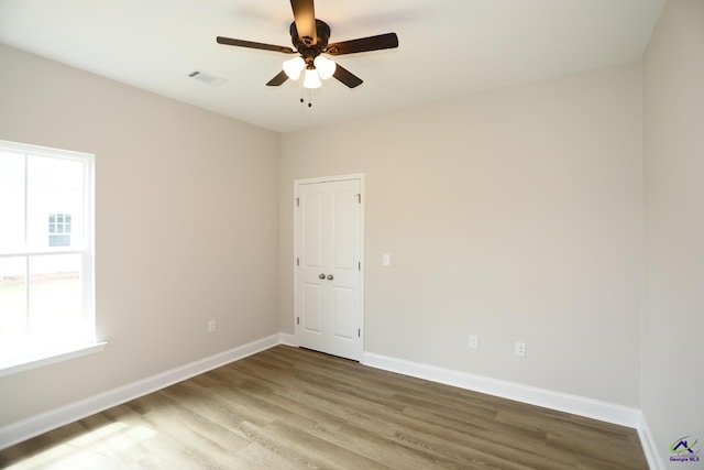 empty room with ceiling fan and hardwood / wood-style floors