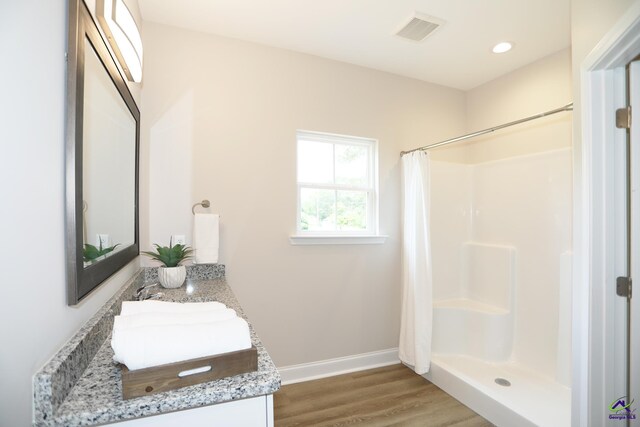 bathroom with hardwood / wood-style flooring, a shower with curtain, and vanity