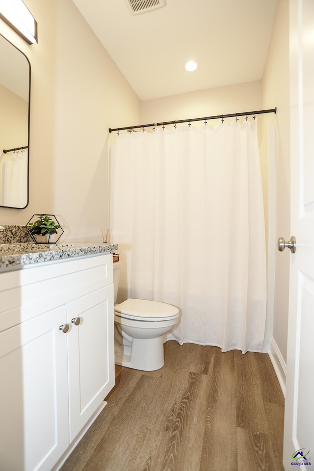 bathroom with hardwood / wood-style flooring, toilet, and vanity