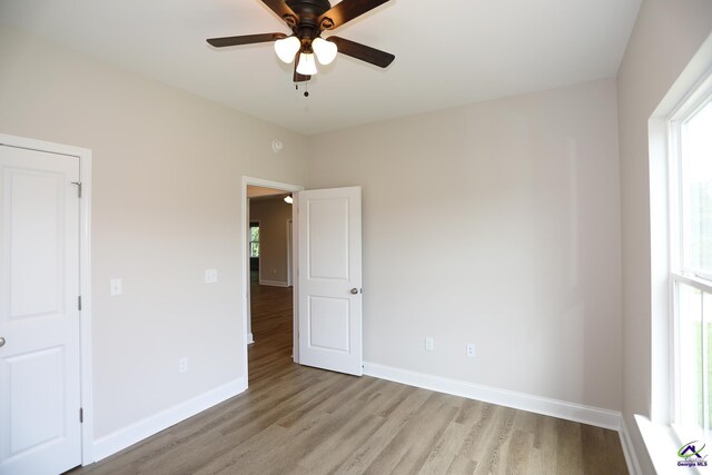 unfurnished room featuring light hardwood / wood-style flooring and ceiling fan