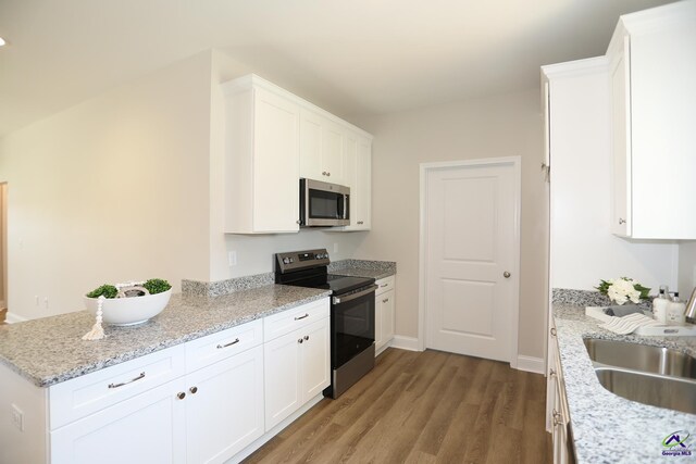 kitchen featuring white cabinetry, stainless steel appliances, sink, light stone counters, and light hardwood / wood-style flooring