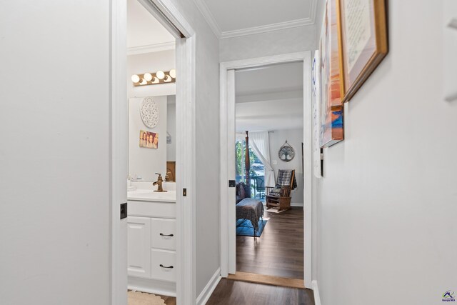 corridor with ornamental molding, sink, and hardwood / wood-style flooring