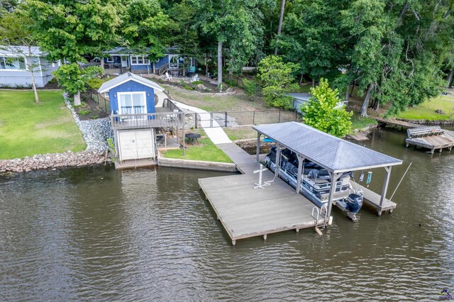 view of dock with a water view and a lawn