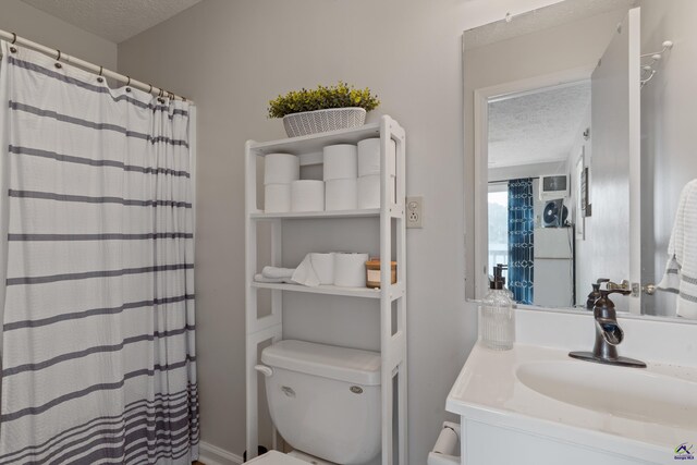 bathroom with vanity, toilet, and a textured ceiling