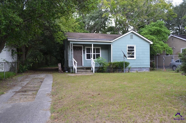 view of front of house featuring fence, driveway, and a front lawn