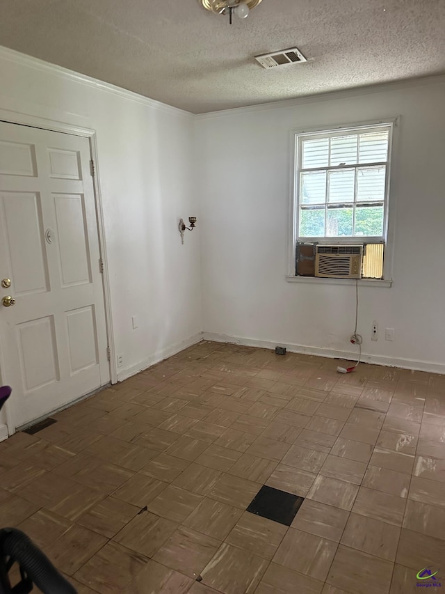 tiled empty room featuring crown molding, cooling unit, and a textured ceiling