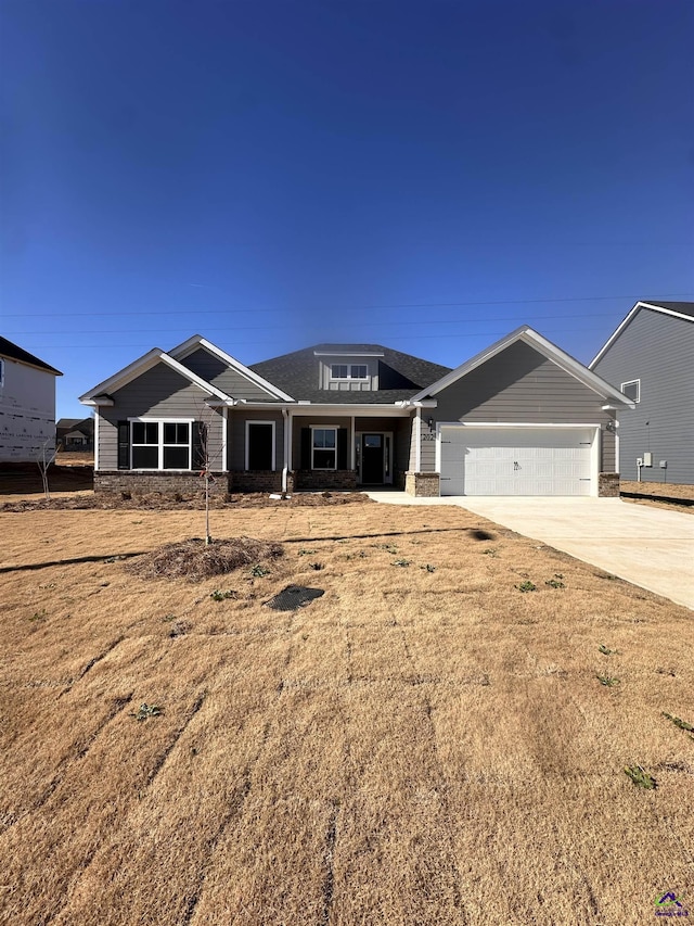 view of front of home featuring a front yard, concrete driveway, and an attached garage